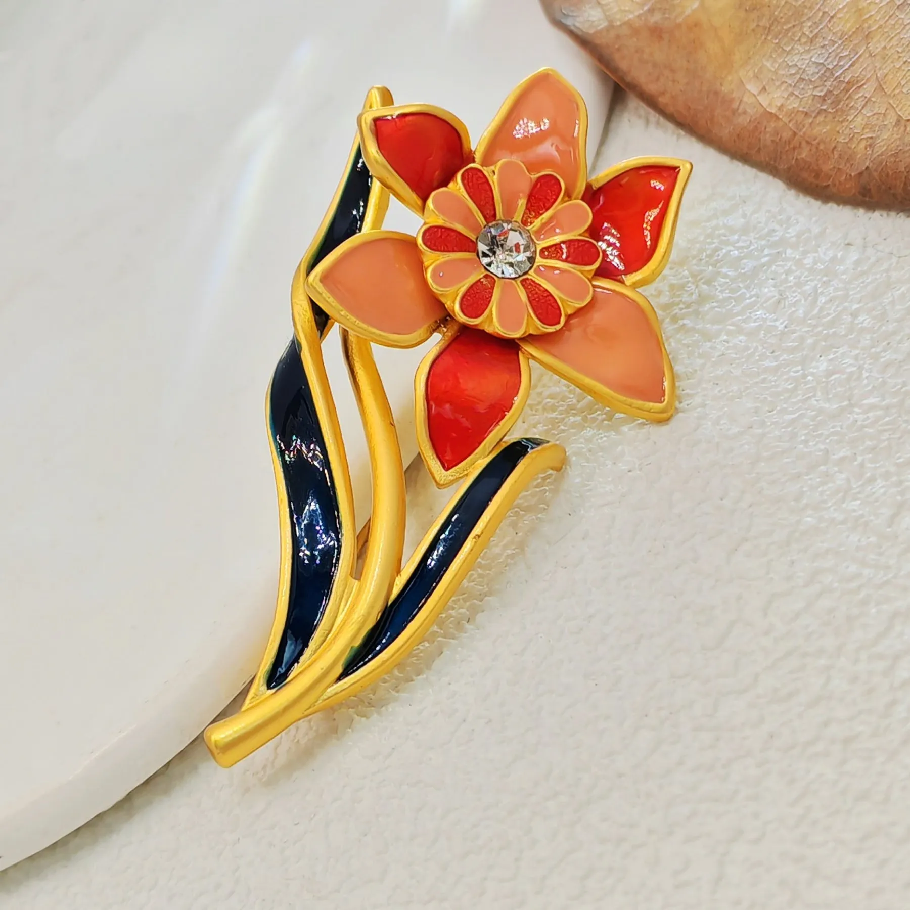 Elegant Gold - toned Enamel Flower Brooch with Crystal Centerpiece