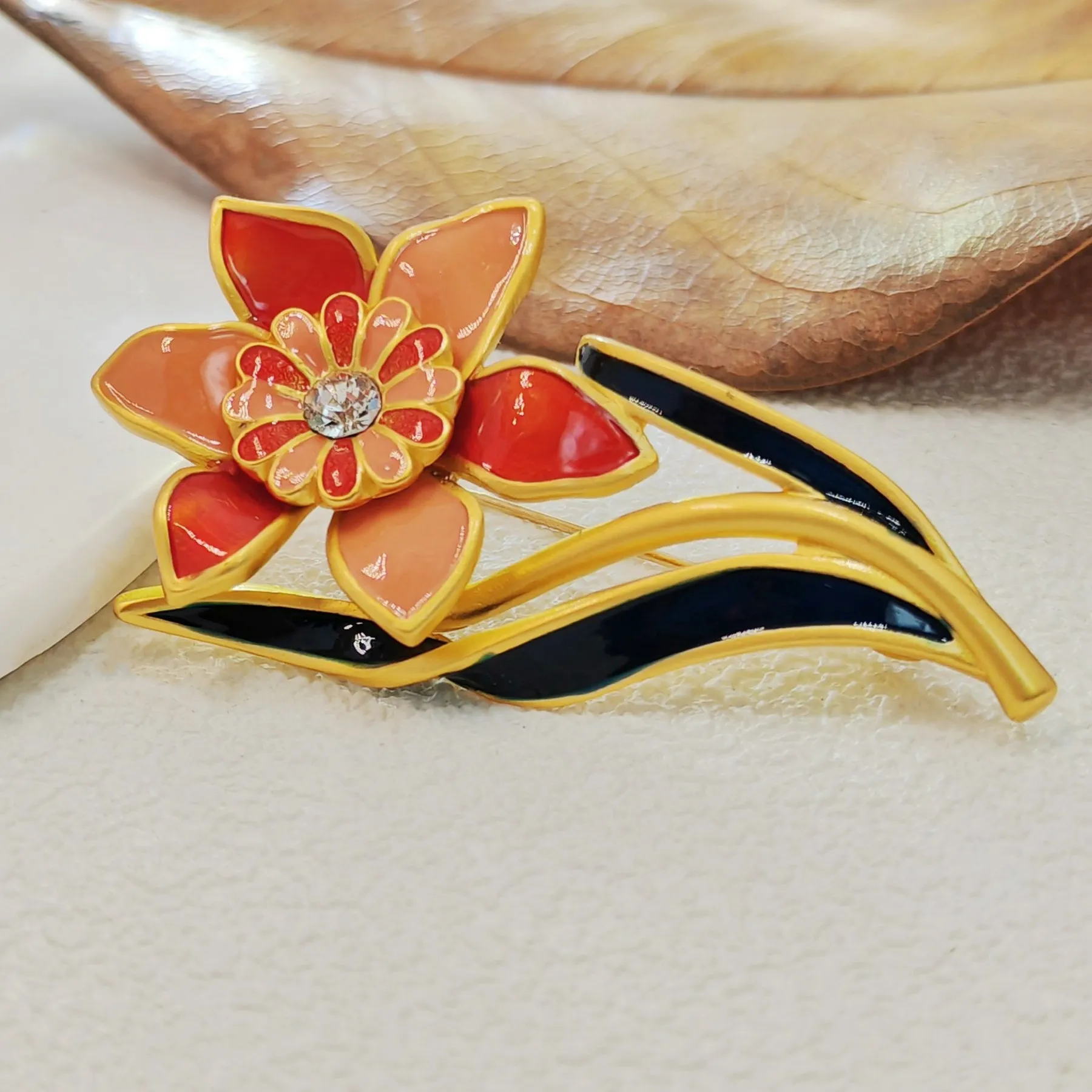 Elegant Gold - toned Enamel Flower Brooch with Crystal Centerpiece