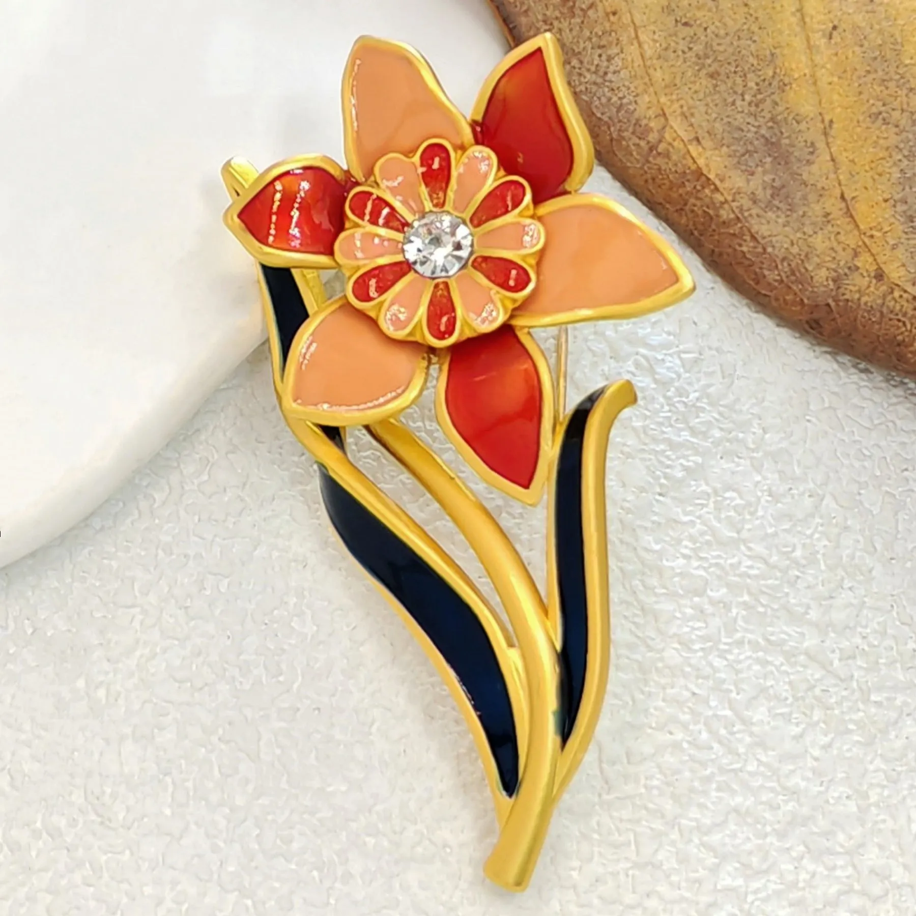 Elegant Gold - toned Enamel Flower Brooch with Crystal Centerpiece