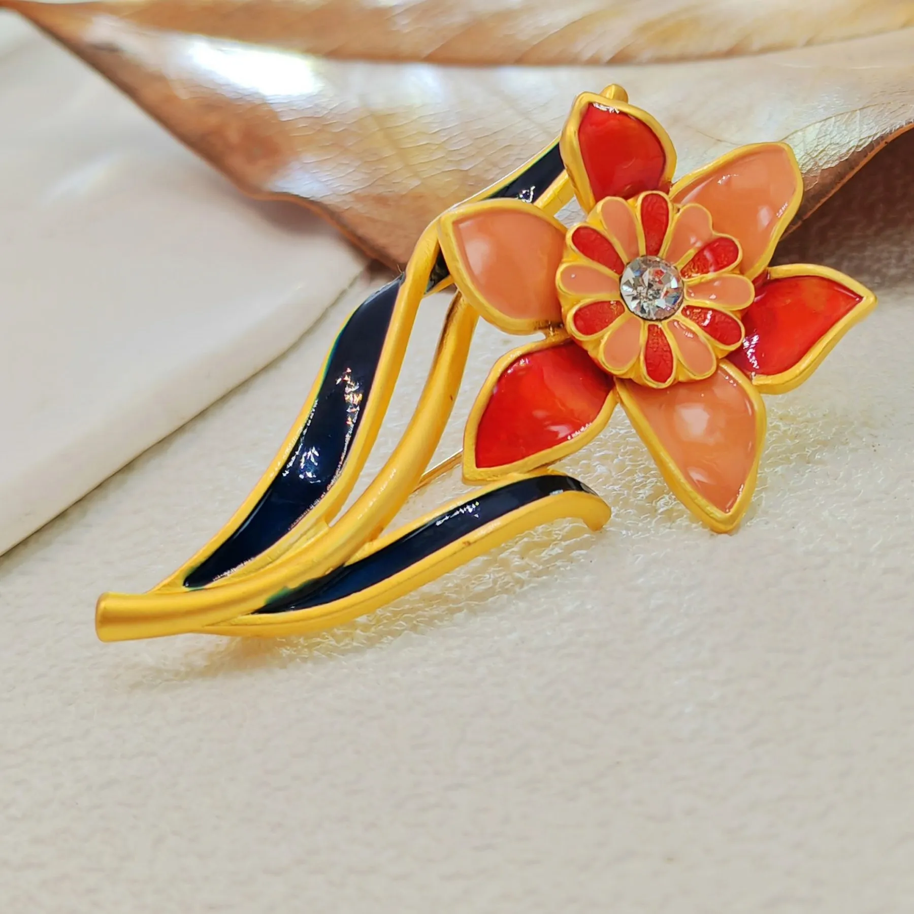 Elegant Gold - toned Enamel Flower Brooch with Crystal Centerpiece