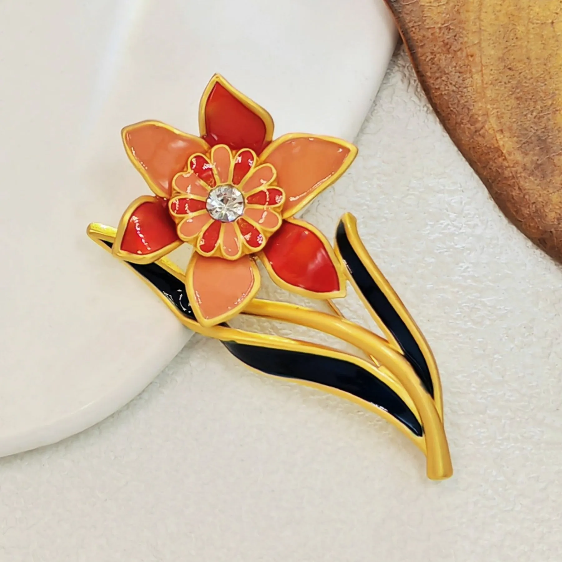 Elegant Gold - toned Enamel Flower Brooch with Crystal Centerpiece