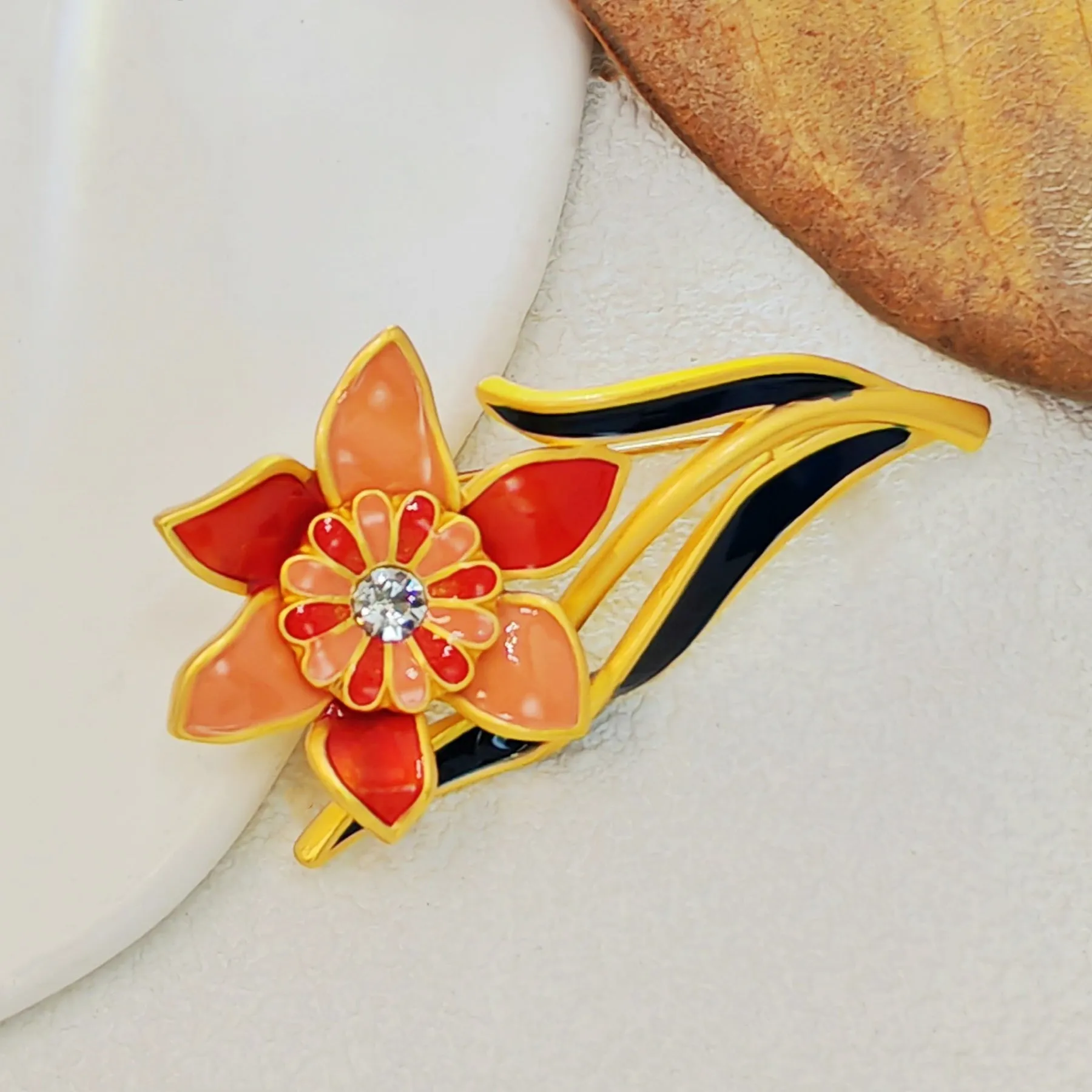 Elegant Gold - toned Enamel Flower Brooch with Crystal Centerpiece
